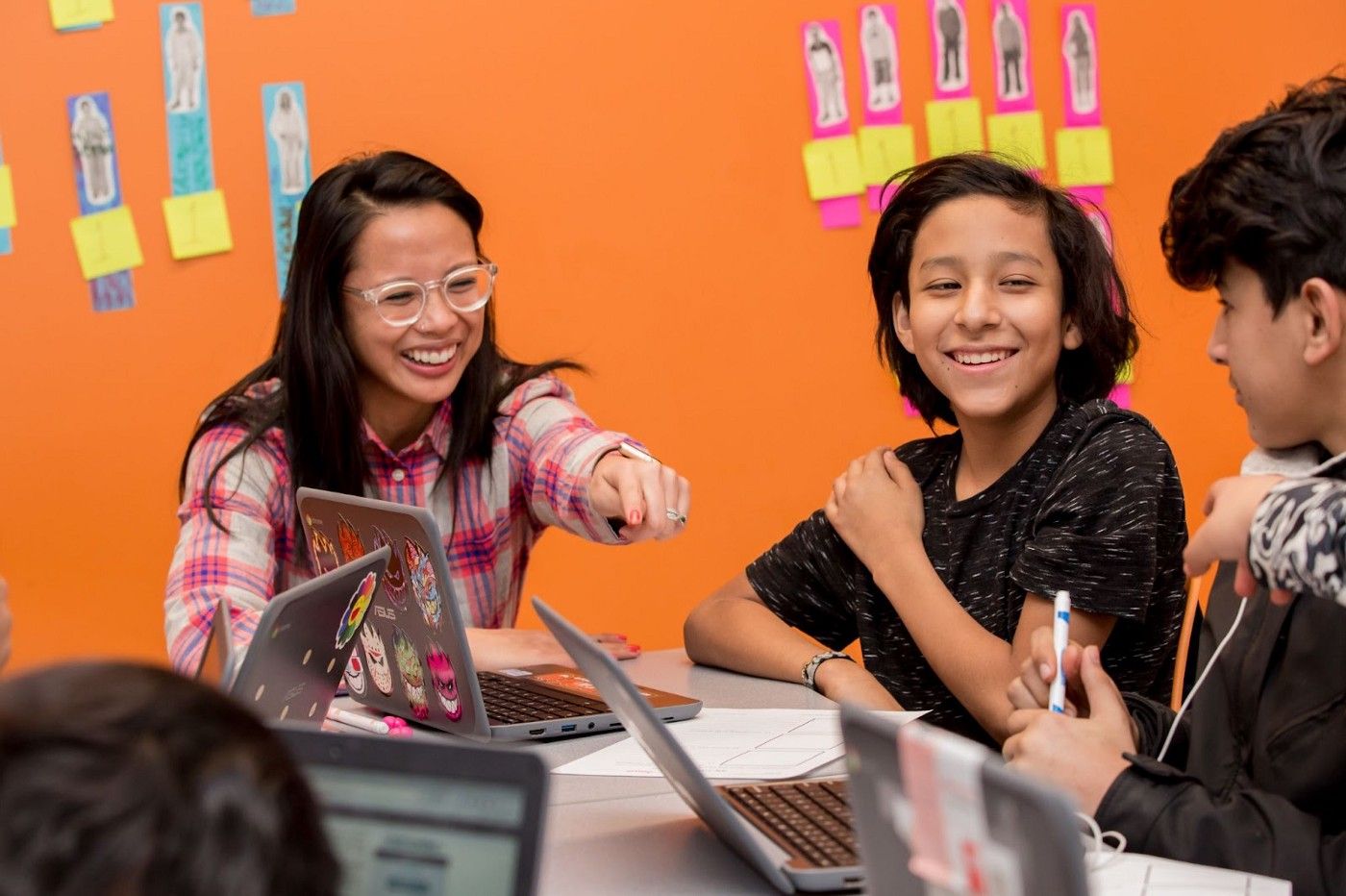 A teacher and two students sitting at a table. The students are reading a CommonLit short story about sports.