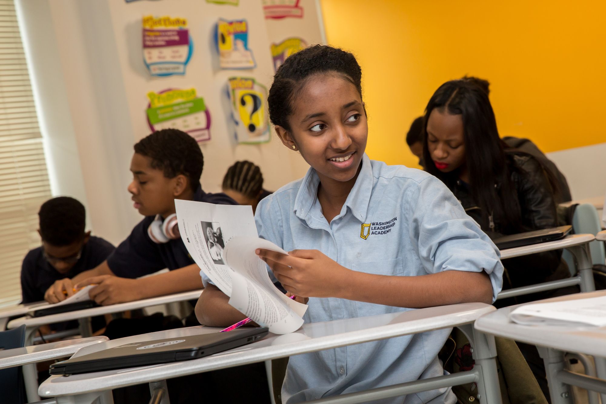 Picture of student flipping through a leaflet while engaging with the class.