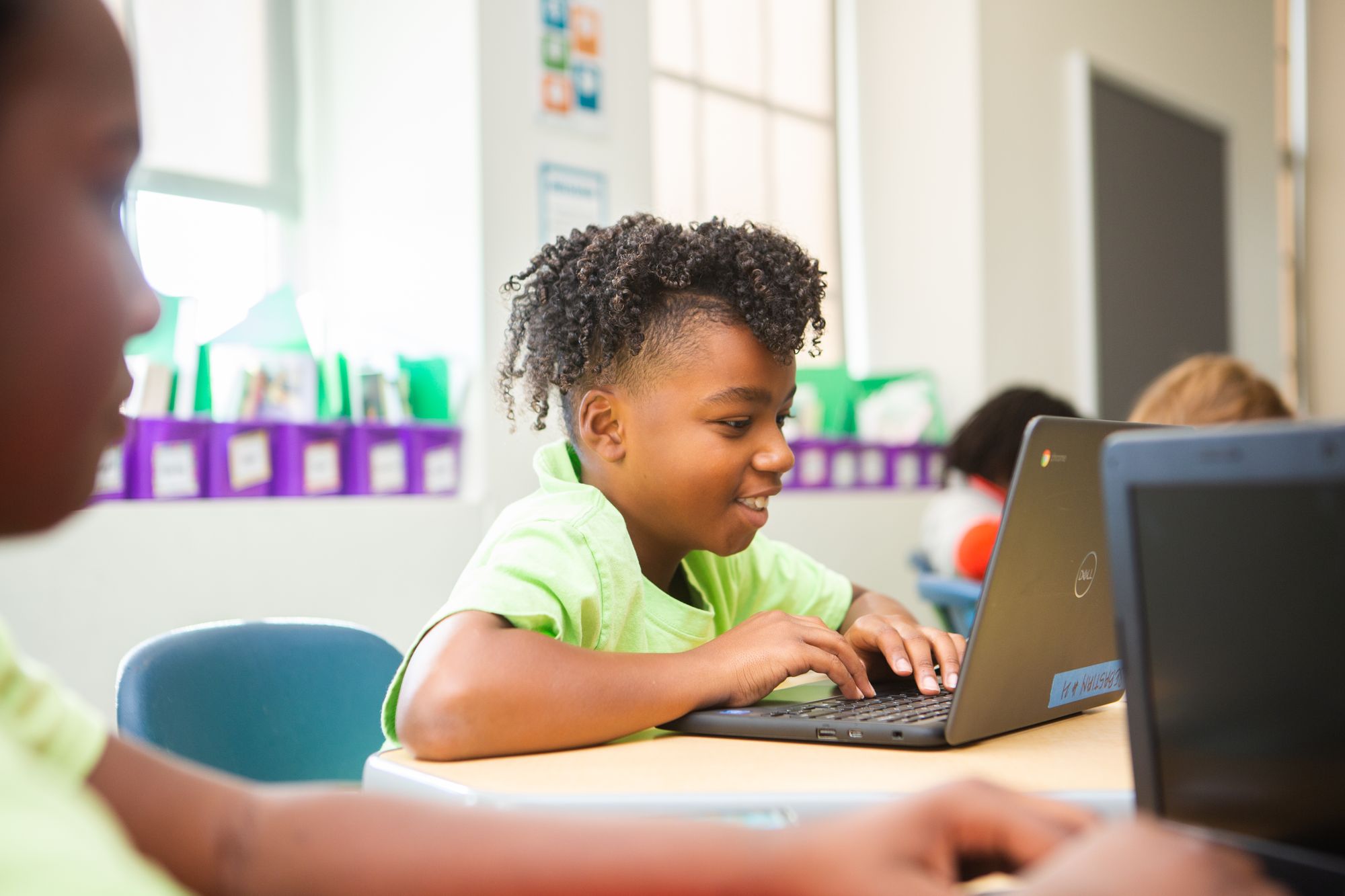 Student sitting at a table and working on a computer. 