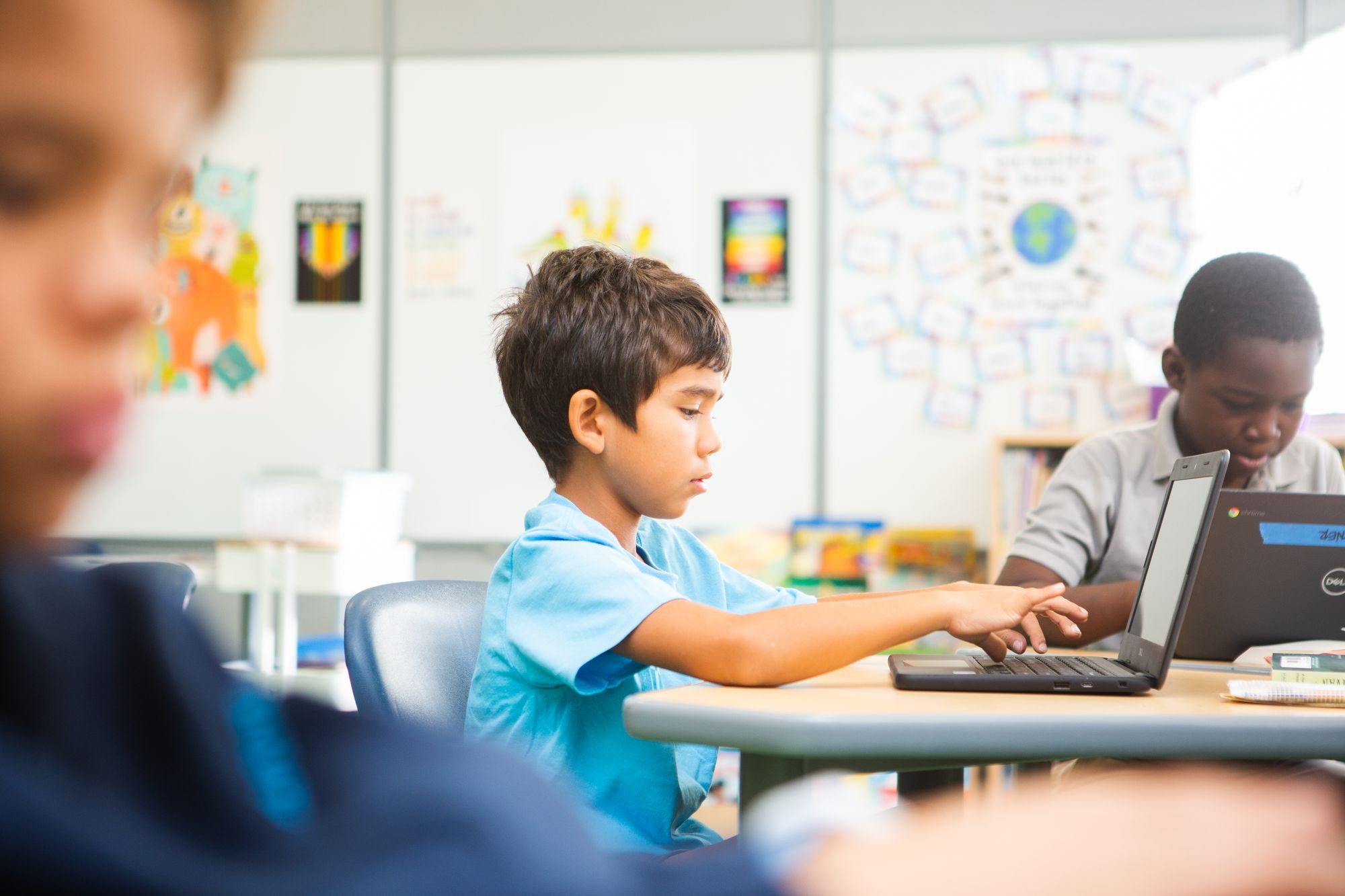 Three boys engage in a digital CommonLit lesson in class.