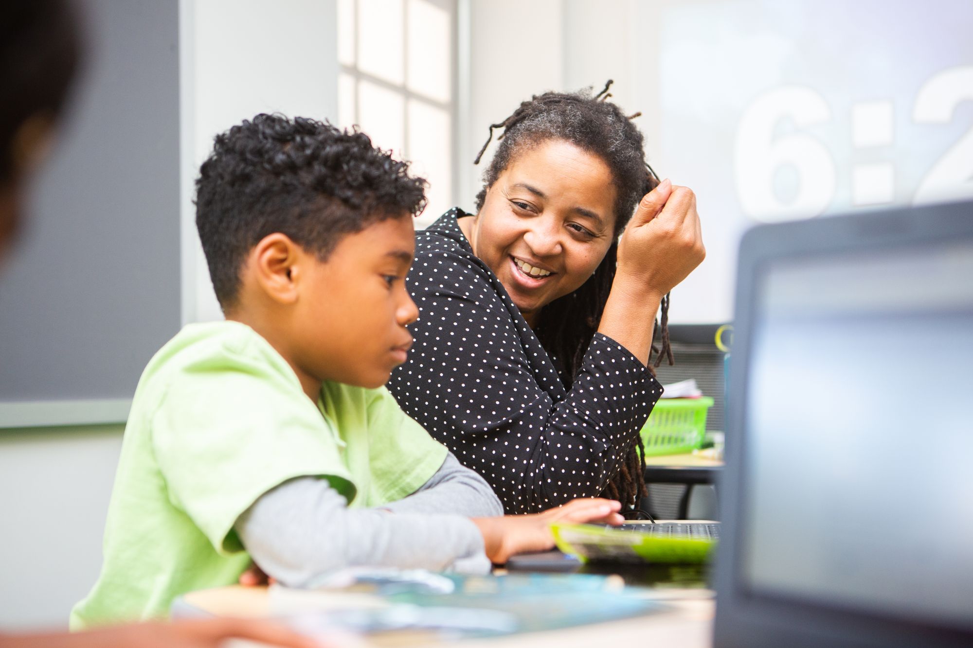 Teacher and student smiling while they work on a CommonLit 360 Lesson.