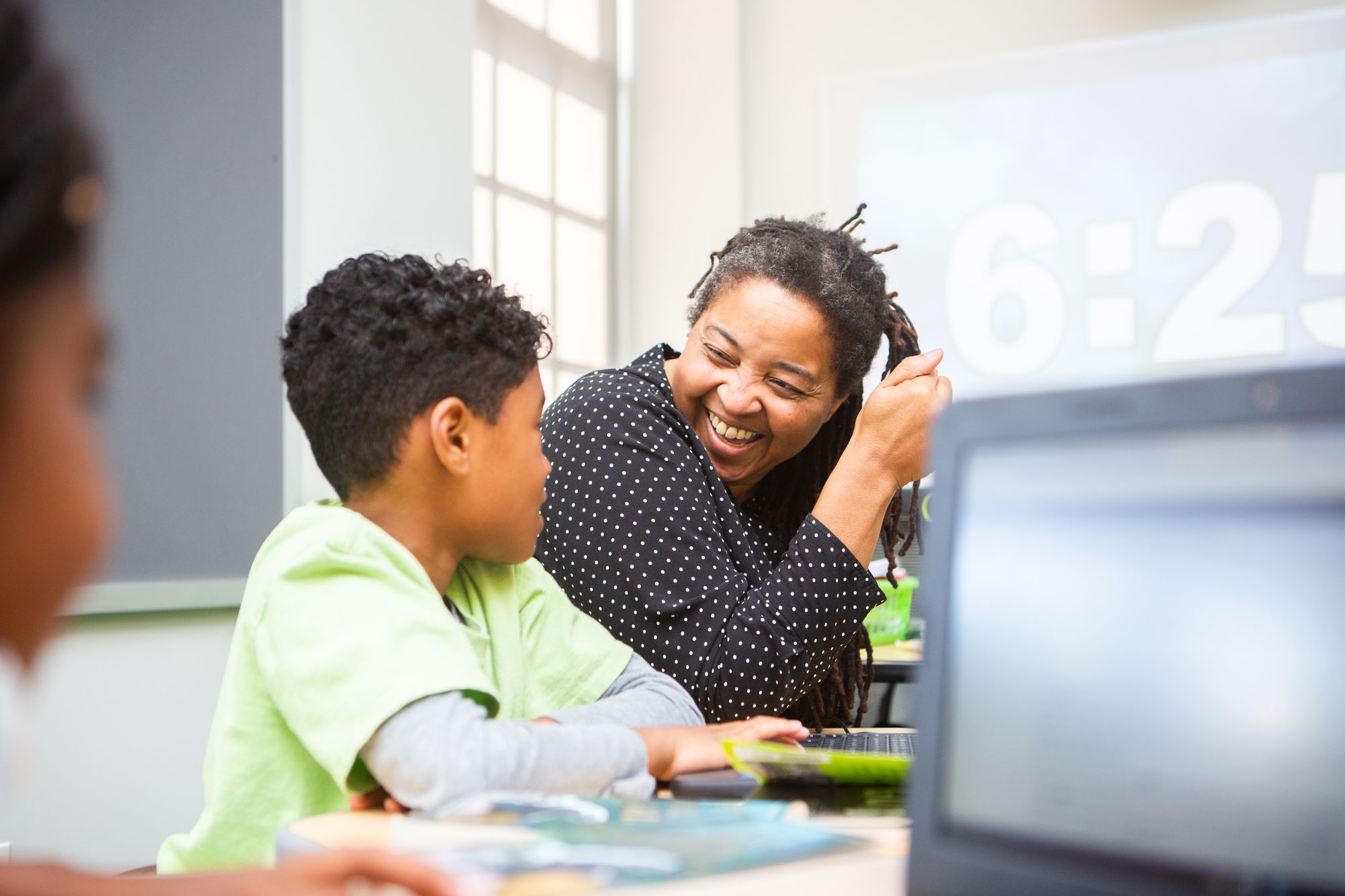 teacher smiling at a student during a CommonLit lesson about mystery stories