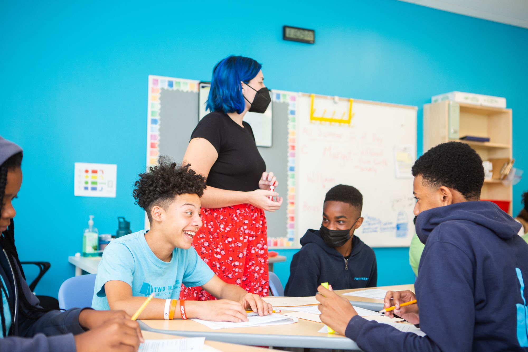 Teenage students smiling around table during discussion about a CommonLit short story. 