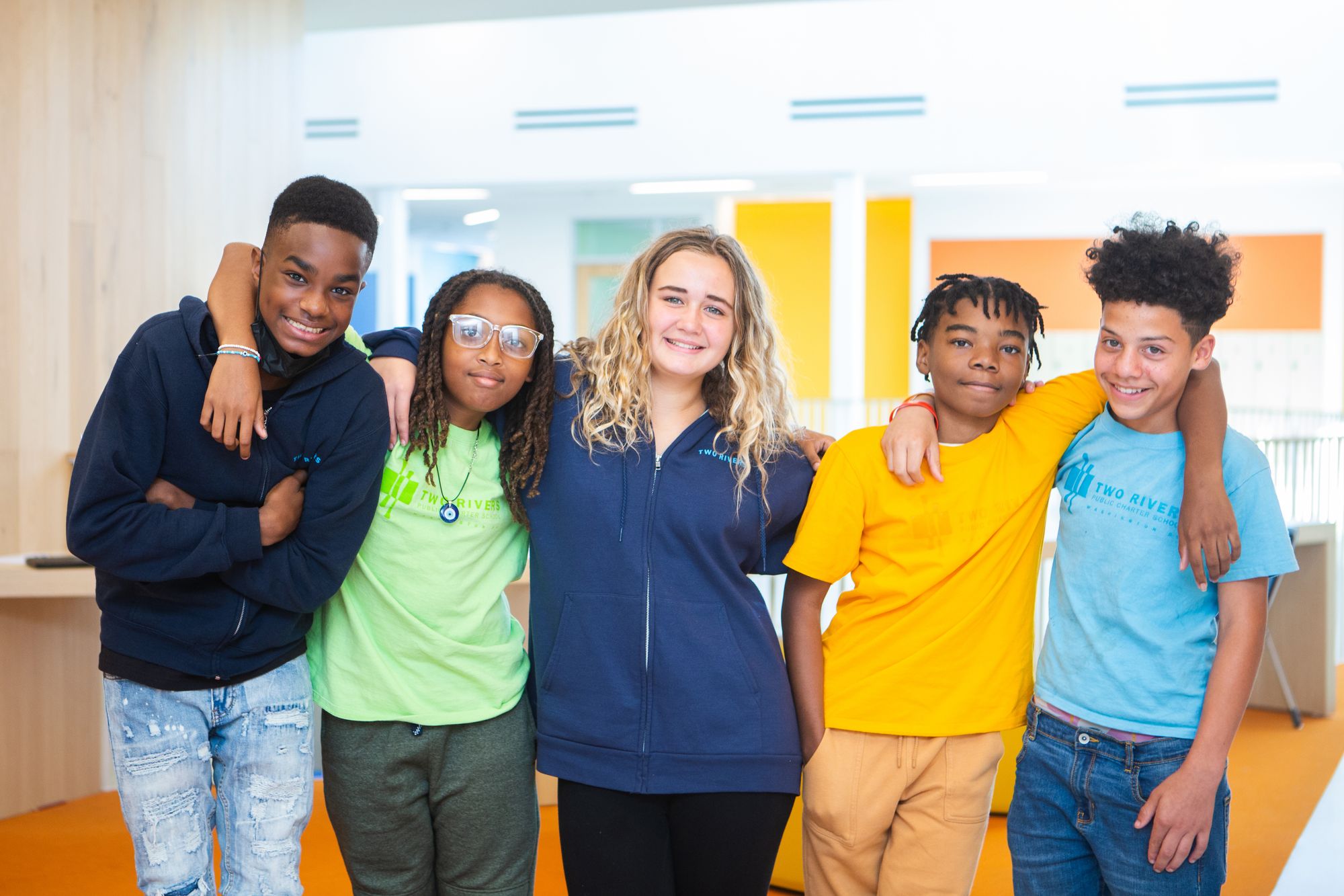 Group of teenage students smile at camera. 