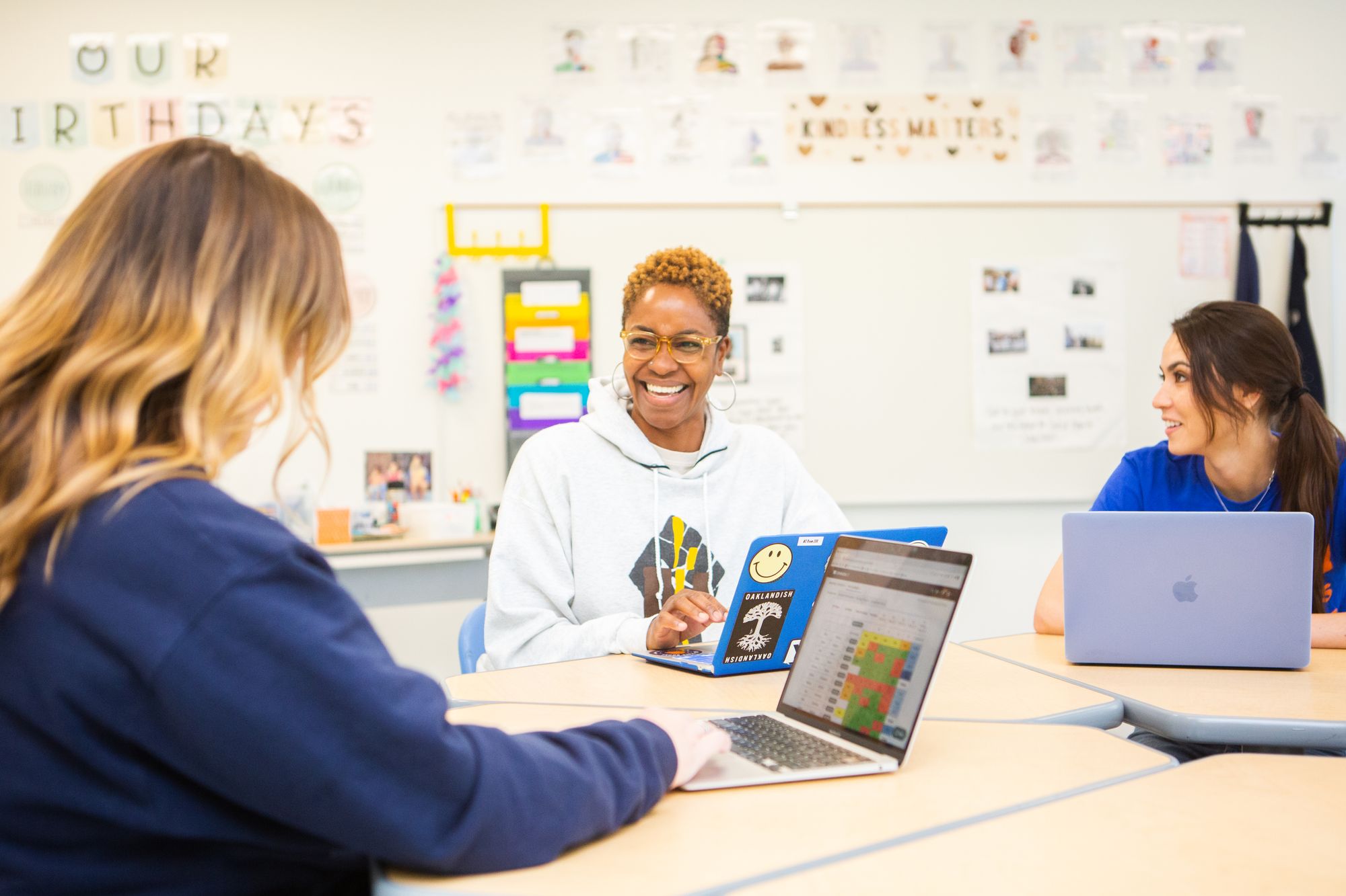 teachers smile at each other as they discuss CommonLit