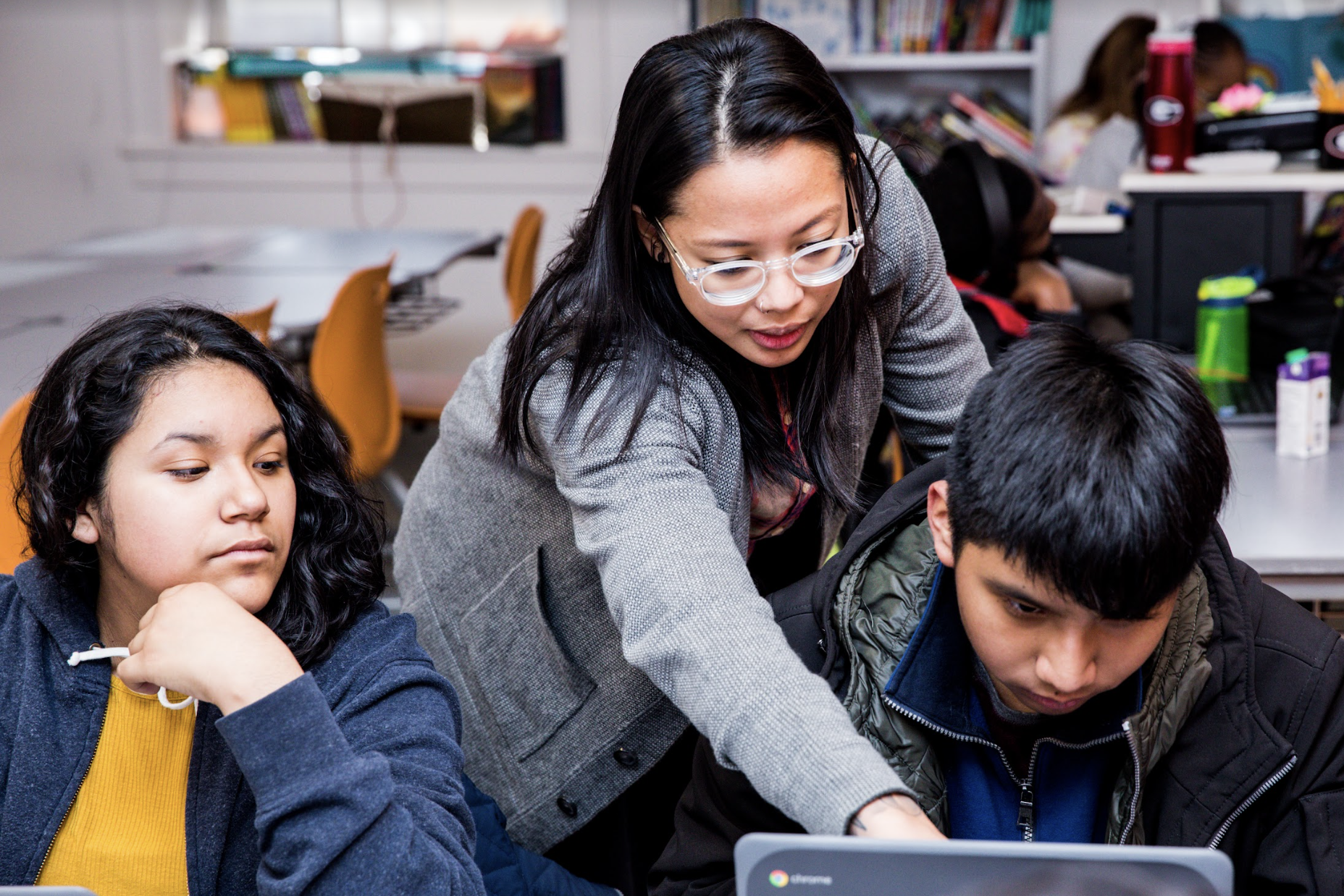 A teacher helps a student with their CommonLit lesson. 