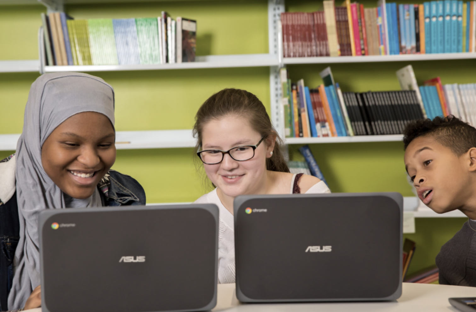 Three students work on laptops.