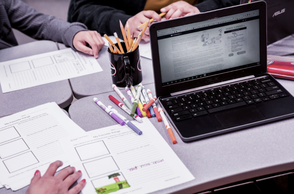 Laptop showing CommonLit lesson on table.